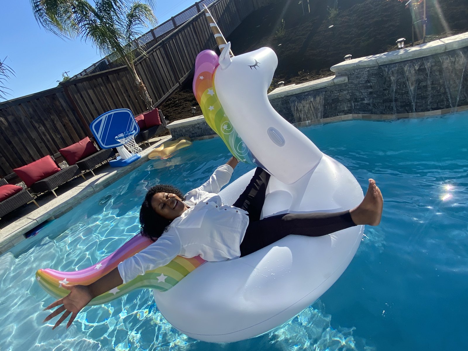 Michele lying back on a unicorn float
